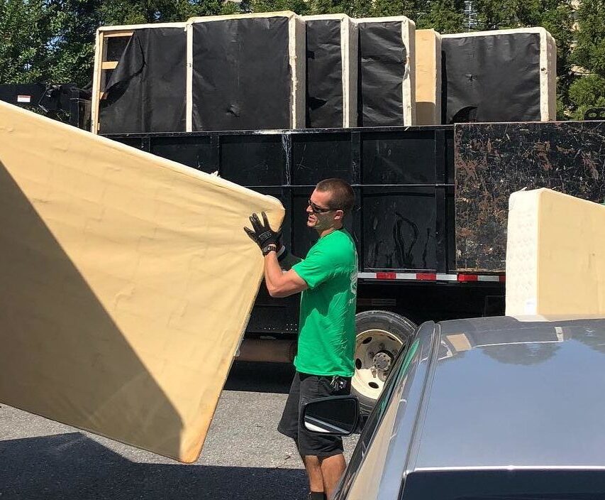 Junk removal professional removing mattress from commercial property